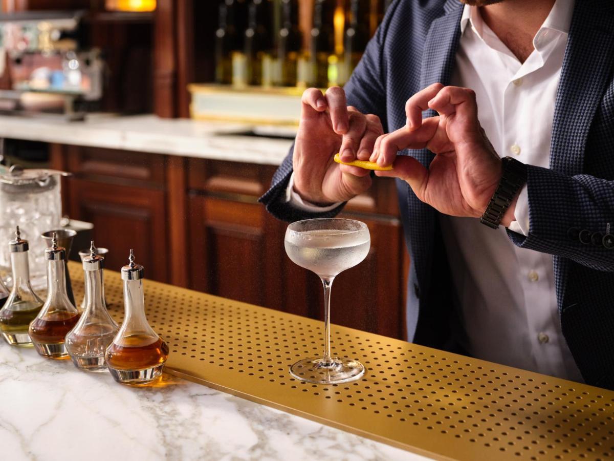 فندق Nomad لندن المظهر الخارجي الصورة A bartender adding a lemon twist to a Vesper cocktail